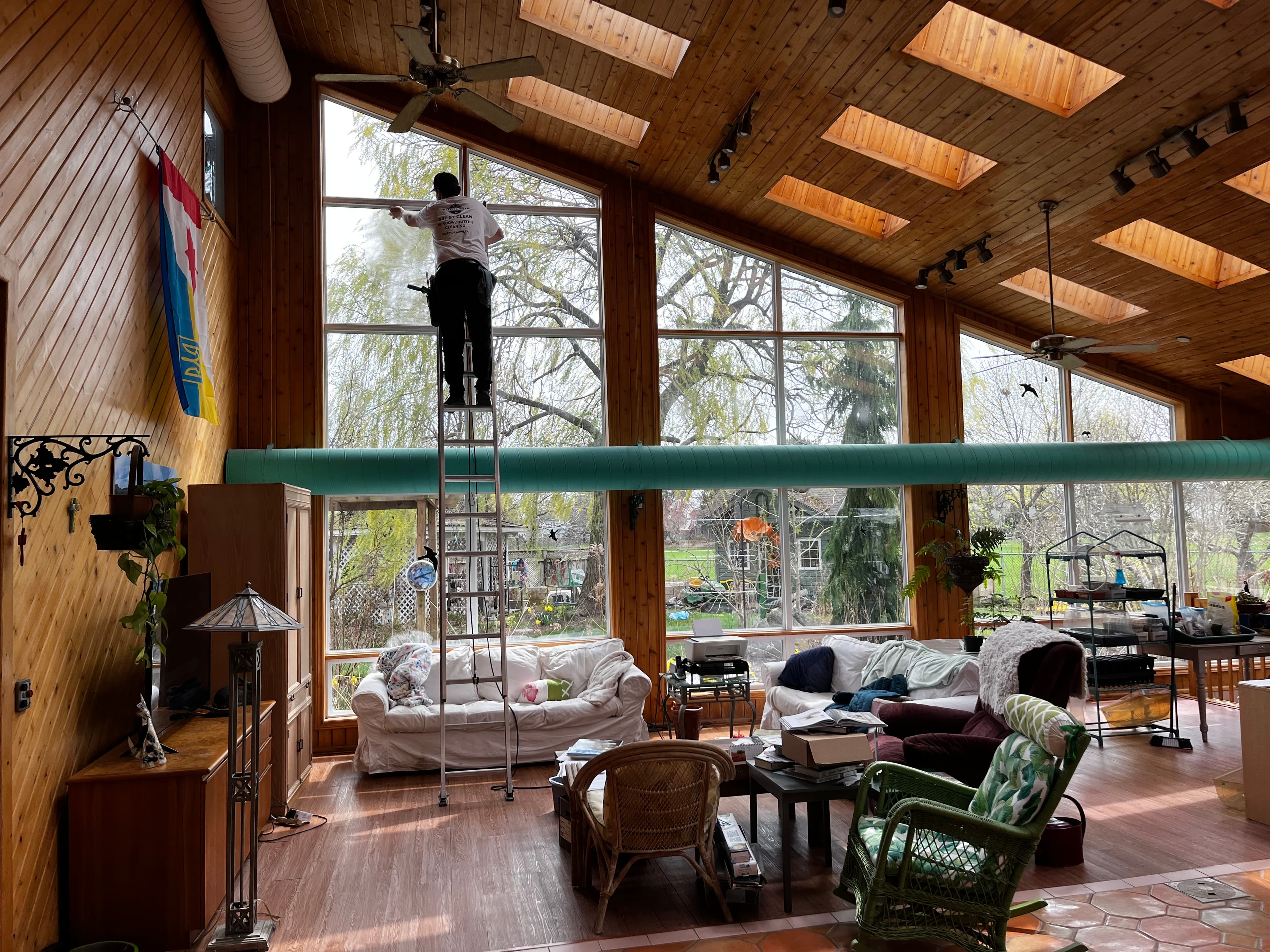 Warrior Wash team member cleaning large interior windows